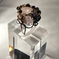 Rose quartz surrounded by dark beads